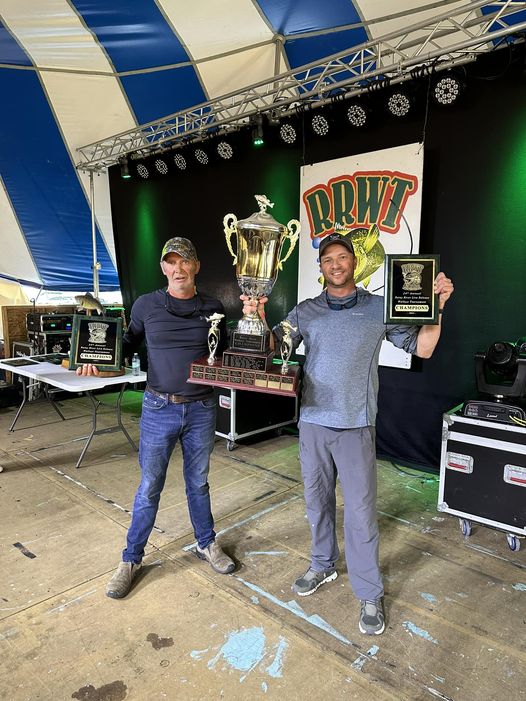 2 guys holding 2 plaques and 2 trophy in between them